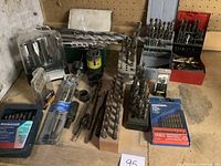 Wide view of drill bits assortment with multiple sets and cases.