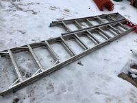 Aluminum 10 ft straight extension ladder laying on snow showing rectangular rungs and structural details