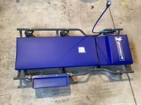 Top-down view of Michelin branded blue padded mechanics creeper with wheels and attached side tray