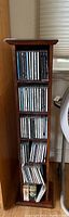 Full view of wooden CD rack holding multiple CDs