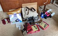 Full lot showing adjustable dumbbells, exercise ball box, water weights and wrist/ankle weights on carpet in front of wood furniture.