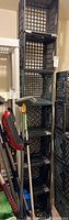Vertical stack of seven black plastic milk crates taped together, showing wear and some dirt.