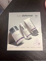 Front view of unopened Dermalogica Age Defense Kit showing three products including Daily Superfoliant, serum, and Skin Perfect Primer.