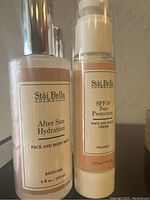 Photo of two unopened Stai Bella skincare products: After Sun Hydration Mist and SPF30 Sun Protectant Cream.