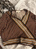 Front view of Michael Kors women's top with geometric pattern and striped wrap bands, size XL