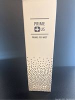 Photo of Moira Prime+US Prime Fix Mist box showing product name and design details.