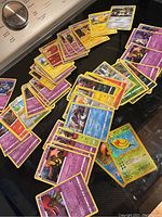Wide view of approximately 50 Pokémon cards spread out showing front and back.