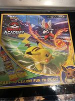 Front view of the Pokémon Battle Academy board game box, sealed in original packaging showing colorful character artwork and branding.