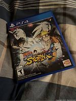 Photo of the PS4 game case for Naruto Shippuden: Ultimate Ninja Storm 4 showing front cover art with characters Naruto Uzumaki, Sasuke Uchiha, and others, rated T for Teen.