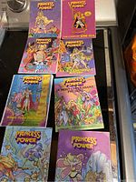 Photo showing seven She-Ra Princess of Power comic books from various angles and titles.