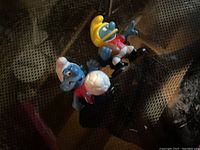 Three vintage sports Smurfs figurines, one holding a soccer ball, one in a yellow baseball helmet, and another in a soccer pose.