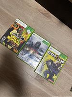Photo showing three Xbox 360 game cases: Dead Rising 2: Undead Nightmare, Valkyria Chronicles, NeverDead.