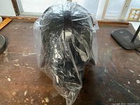 Darth Vader helmet-shaped popcorn bucket sealed in original plastic wrap on a wooden surface