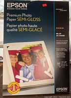 Front of Epson Premium Photo Paper box showing branding, product name, size, sheet count, and image of printed photo.