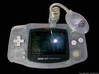 Front view showing Game Boy Advance Glacier with Super Mario World 2 on screen, light attachment on top left.
