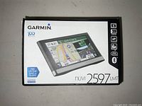 Front view of Garmin Nuvi 2597LMT GPS packaging showing the device image, 5 inch screen size, and included features like lifetime maps and traffic.