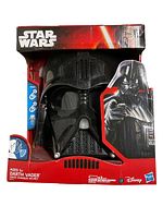 Front view of new Darth Vader voice changer helmet in original red Star Wars box, showing helmet and packaging with some visible box damage.