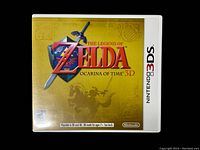 Front cover of The Legend of Zelda Ocarina of Time 3D in original white Nintendo 3DS case with yellow background and Zelda logo