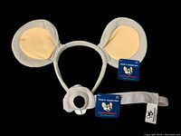 Gray fabric headband with large ears and separate nose piece, tags attached, scuff visible on one ear, set displayed on a light background.