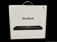 Front view of original MacBook box with Apple logo, MacBook name, and image of closed black MacBook laptop