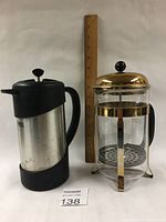 Two Bodum coffee makers side by side with a ruler for size reference showing the glass French press and stainless steel thermos style coffee maker