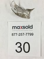 Photo of silver butterfly pendant showing front side with detailed wing patterns.