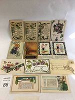 Photo shows 12 assorted early greeting postcards with floral and children themes, arranged on white background under natural light.