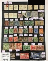 Full view of vintage Great Britain stamps on black display board with value tags attached