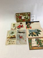 Photo showing all 7 vintage Christmas postcards laid flat on a white surface.