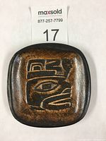 Top view of the square decorative tray showing the Tsimshian Bear and Man raised design in dark and light brown tones.
