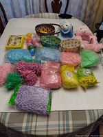 Full display of craft and Easter items including baskets, artificial grass, plastic eggs, and plush toys on a table