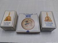 Photo of original boxed M.J. Hummel bells from 1980 and 1981, and 1979 plate.