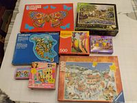 Top-down view of seven puzzle boxes on a table showing images and brands