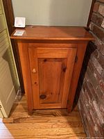Front view of wood jelly cabinet showing door and knob