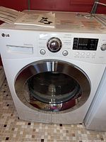Front view of white LG dryer with manuals placed on top