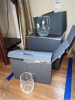 Two stemless glasses displayed on and next to Waterford boxes