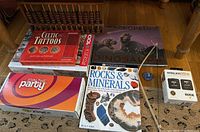 Overview photo showing all items in the lot, including microphone system box, abacus, puzzle, books, and additional items.