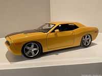 Front-side view of the yellow 1:18 scale die-cast Dodge Challenger model showing detailed exterior and chrome rims