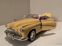 Front angled view showing front grille, headlights, and open driver's side door and trunk.