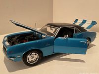 Photo showing side view with open driver door and hood lifted, details of interior and engine visible.