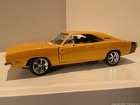Side profile of the yellow 1969 Dodge Charger die-cast model showing detailed wheels and side logo.