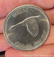 Obverse of the 1967 Canadian Centennial Silver Dollar showing a flying Canada goose and inscriptions DOLLAR CANADA 1867-1967.