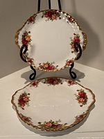 Two 9-inch Royal Albert Old Country Rose dessert plates with floral pattern and gold trim, one plate on display stand, the other lying flat.