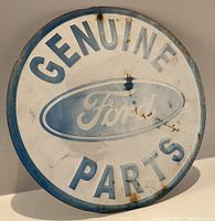 Front view of round metal sign with GENUINE PARTS text and Ford logo with visible rust and wear.