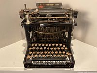 Front view of black Remington Standard Typewriter No.7 showing 'Remington' decal on paper table and 'Remington Standard Typewriter No.7' on front.