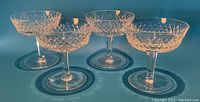Four Waterford crystal champagne coupe glasses shown from a slight side angle highlighting the bowl shapes and cut crystal patterns.