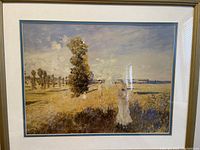 Framed art print of people walking in sunlit rural landscape with trees.