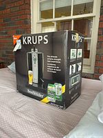 Boxed Krups BeerTender home draft beer machine, showing product branding and use on box.