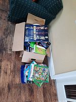 Box of assorted children's and educational books showing titles including 'The Human Body'.