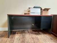 Side view showing black base with two vertical drawers on the right and wood finish top.